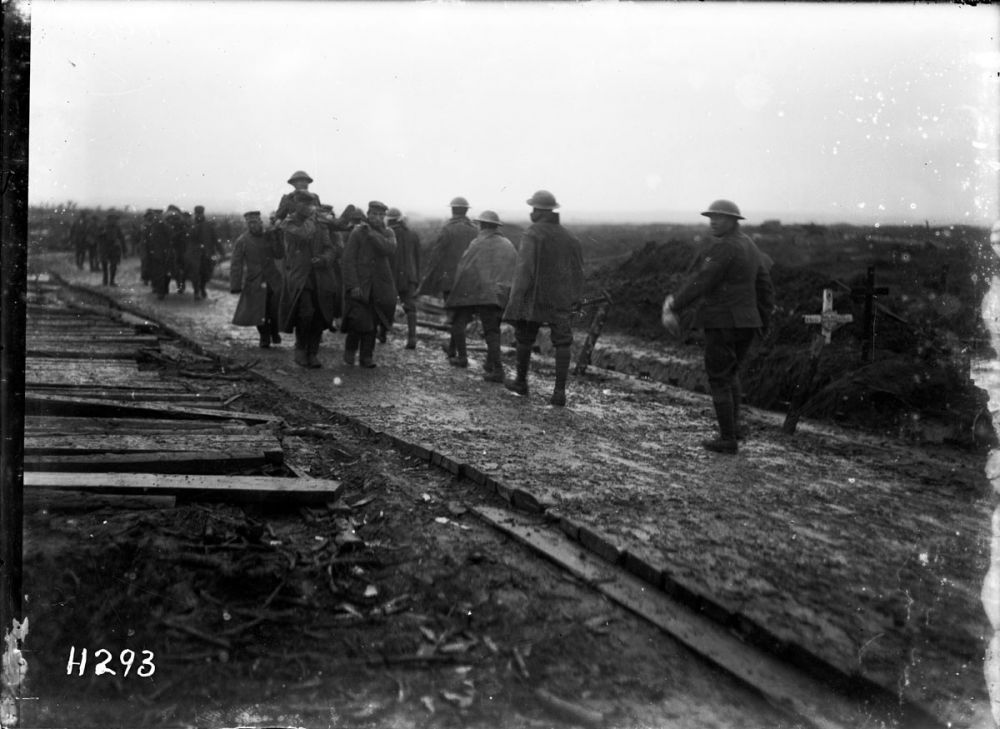 New Zealand troops pass German prisoners carrying Allied wounded on a road on the same day as the Battle of Broodseinde, 4 October 1917.